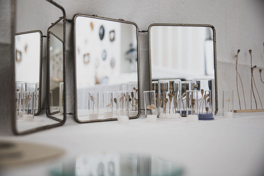 Anciens miroirs chinés et tiges de coquelicots en éprouvettes